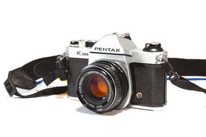A 35mm film camera, specifically the Pentax K1000.